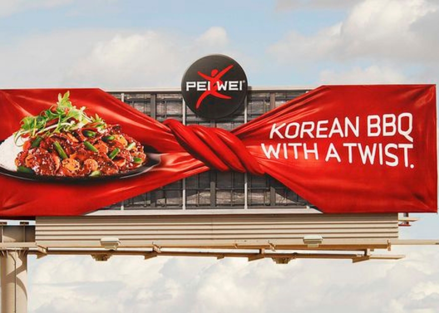 Iklan Reklame billboard mengenai promosi makanan dengan desain unik dan warna merah yang menarik